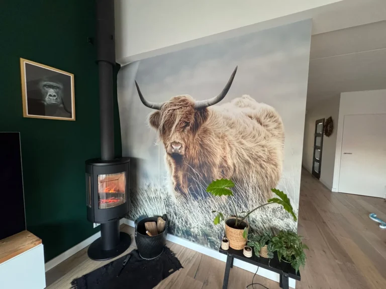 Fotobehang met Schotse hooglander naast een houtkachel