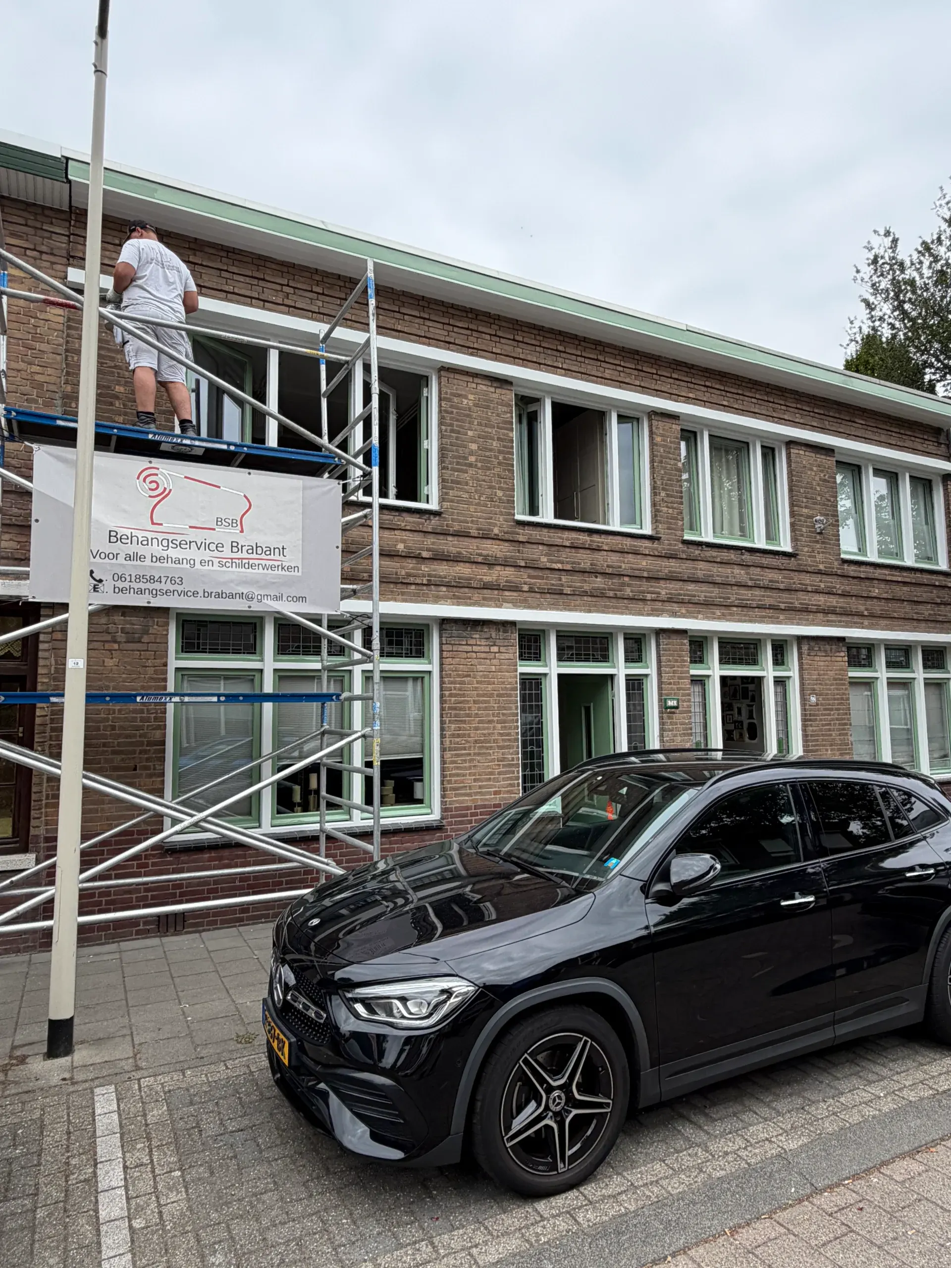 Steiger bij een appartementencomplex tijdens schilderwerk